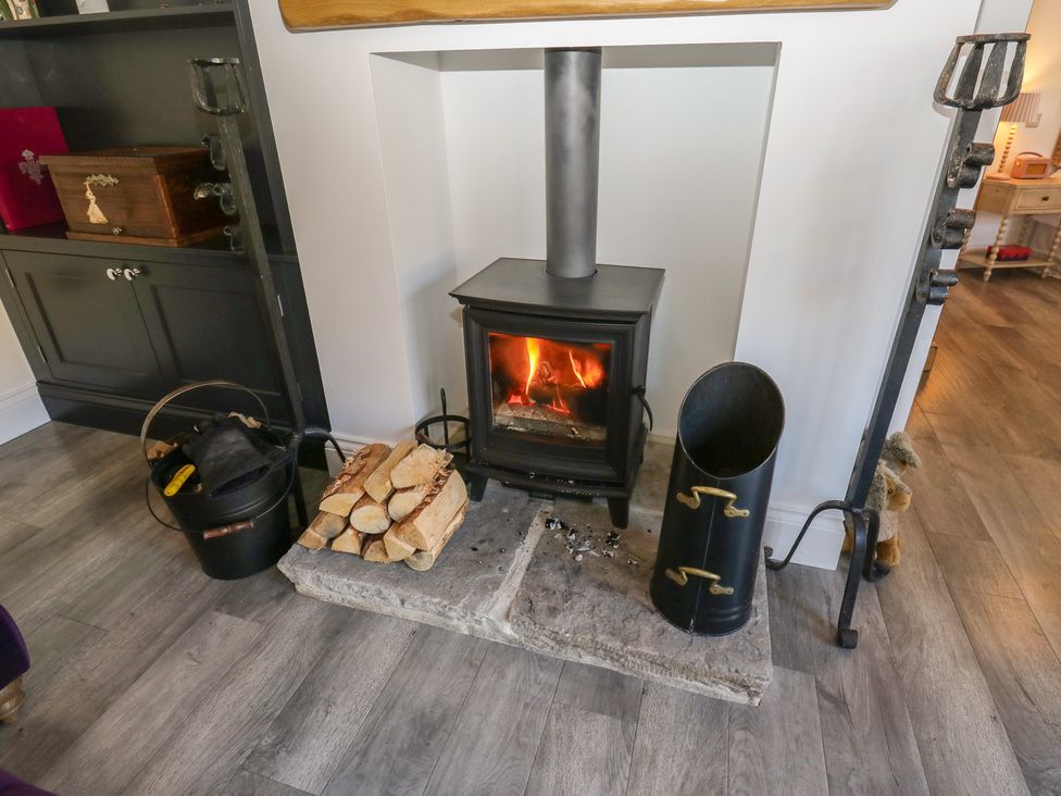 A fireplace with logs and a bucket at The Summerhouse in 