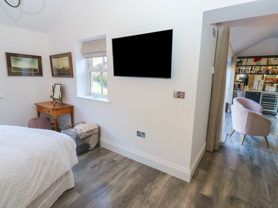A bedroom featuring a bed, television, and a table with a mirror at The Summerhouse in 