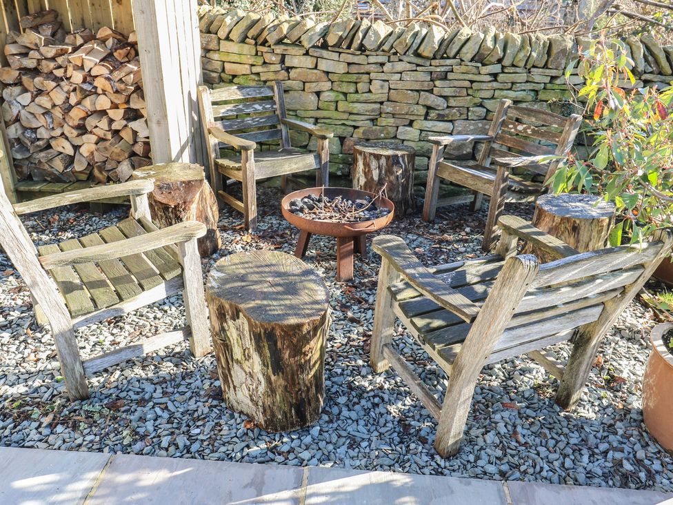An outdoor seating area with wooden chairs and a fire pit at The Summerhouse in 