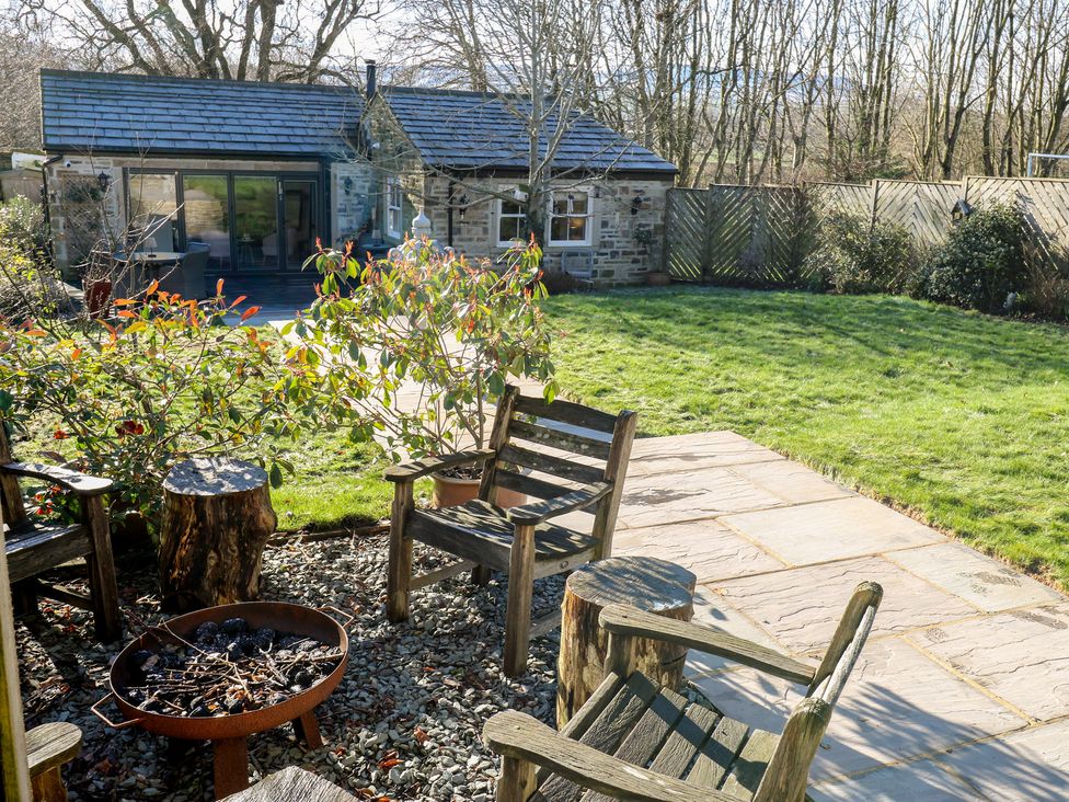 A garden with wooden chairs and a fire pit at The Summerhouse in 