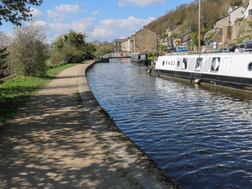 A canal with boats and a pathway alongside at The Summerhouse in Kildwick