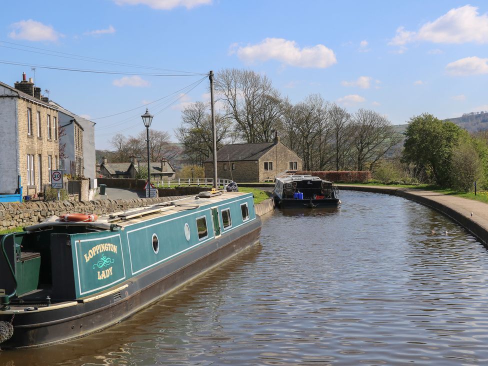 A canal with two boats and houses alongside at The Summerhouse in Kildwick