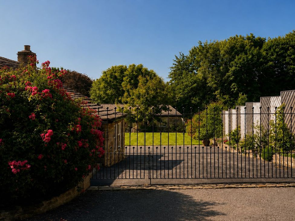 A view of a garden with a gate and flowers at The Summerhouse in Kildwick