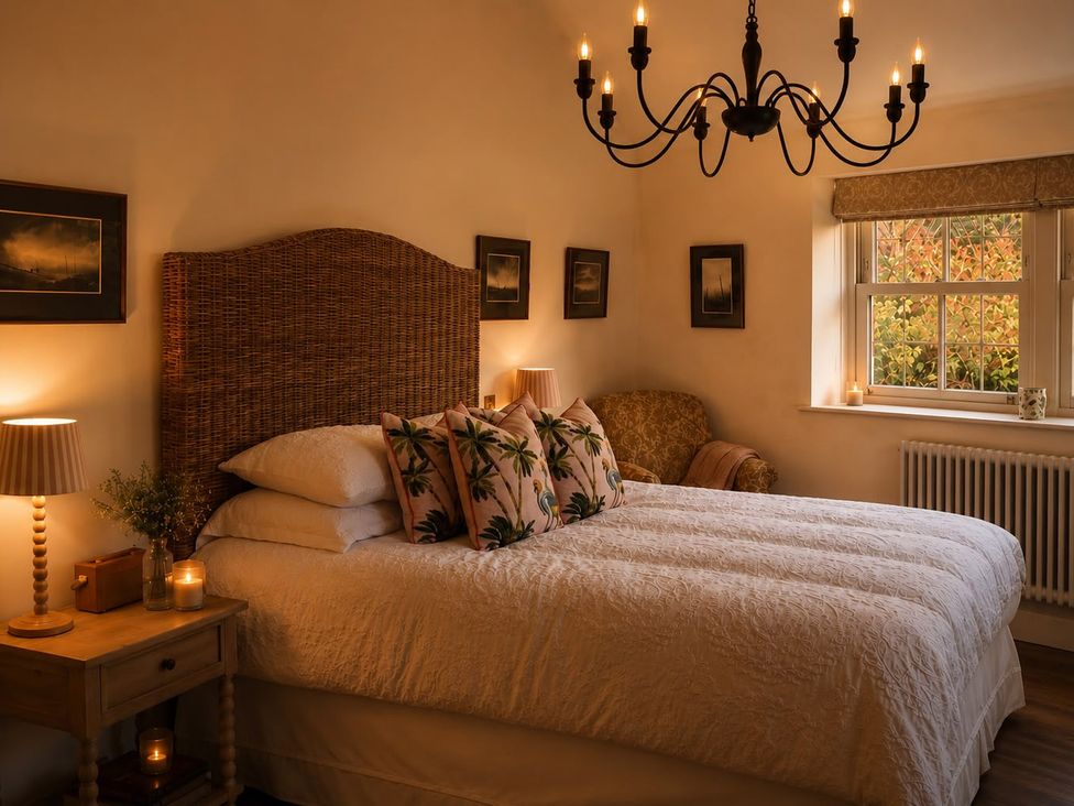 A bedroom with a bed, armchair and window at The Summerhouse in Kildwick