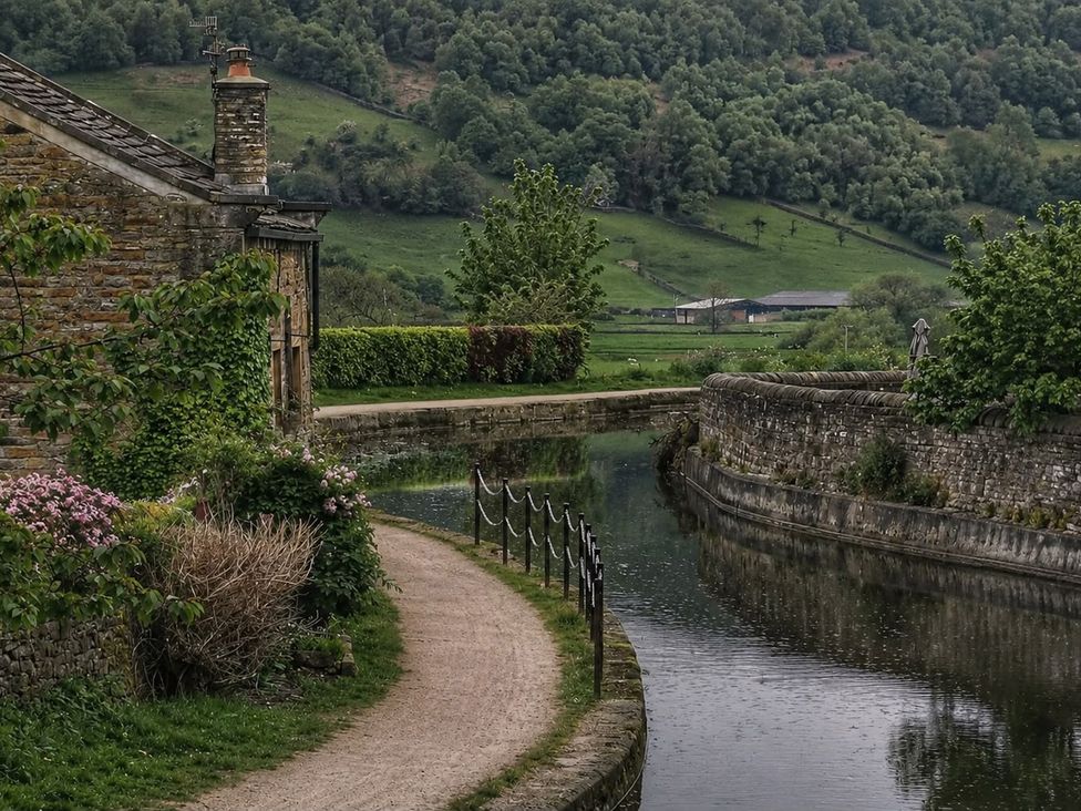 A building beside a waterway with a pathway at The Summerhouse in Kildwick