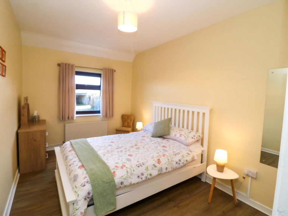 A bedroom with a bed and bedside table at Thadg and Hannah’s Miltown