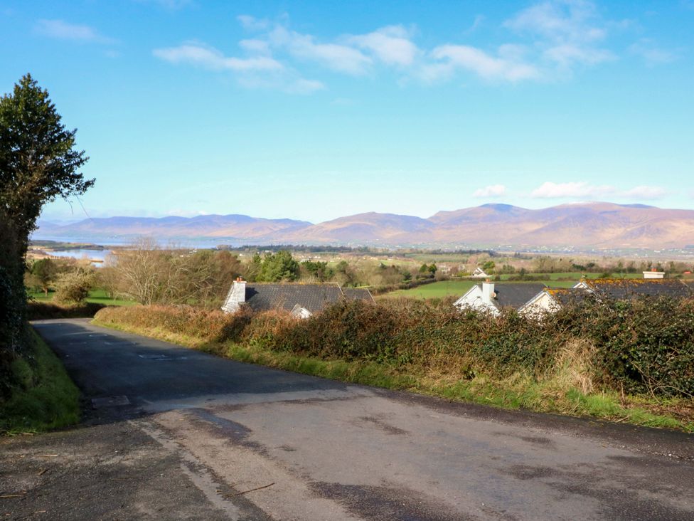 A scenic view of a road leading down to houses with mountains in the background at Thadg and Hannah’s in Miltown