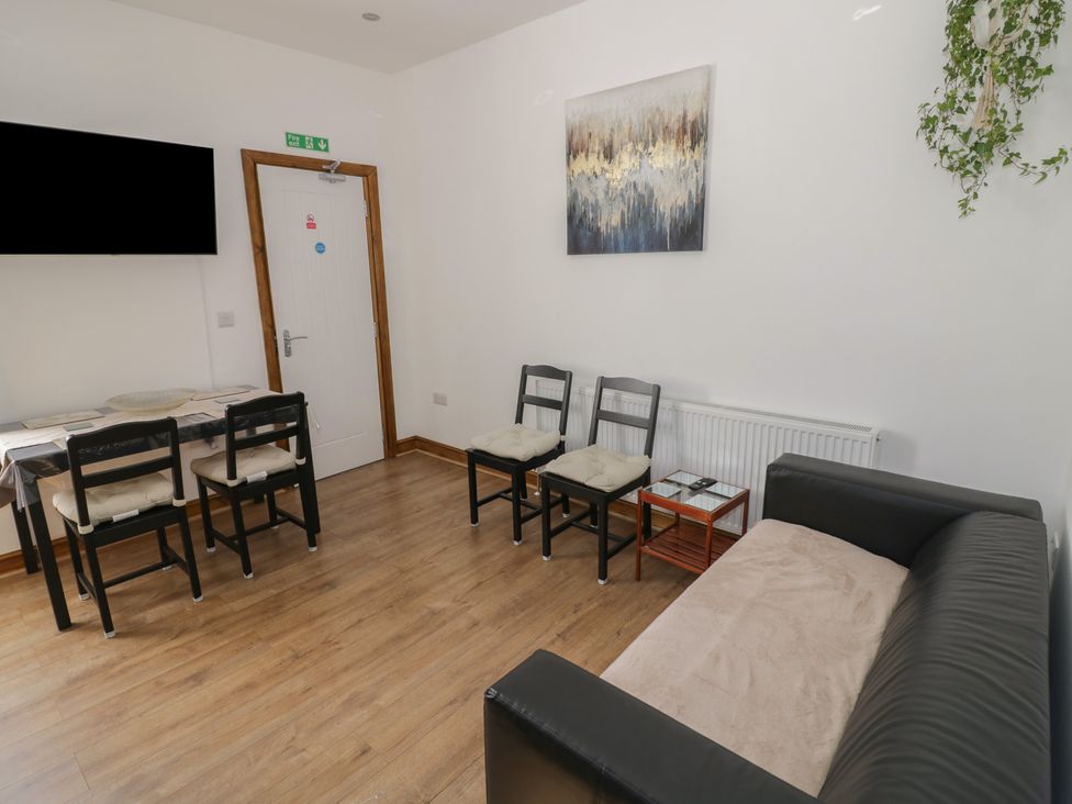A living room with a sofa, chairs, and a table at JMG House West Bromwich