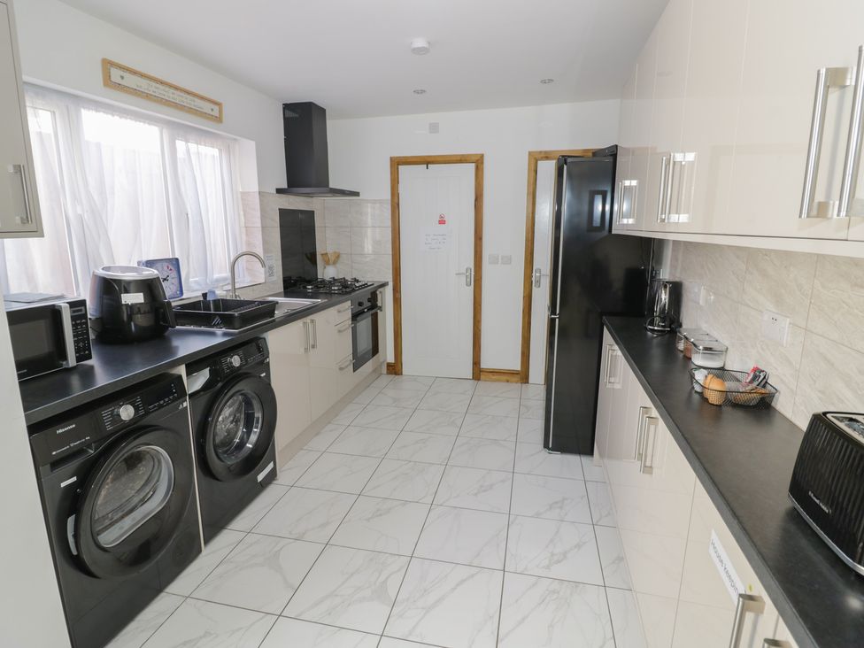 A kitchen with appliances and counters at JMG House in West Bromwich