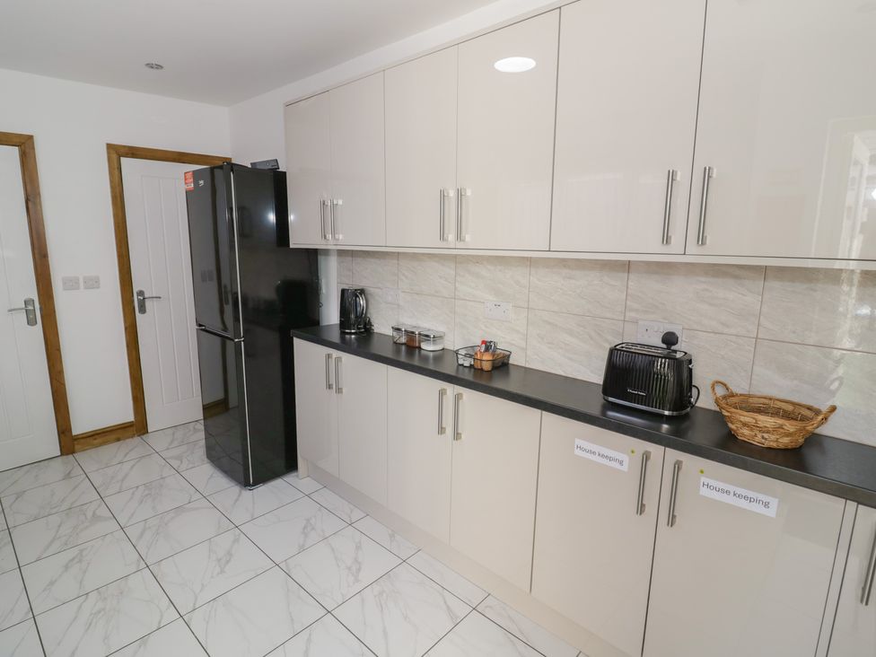 A kitchen with a refrigerator and countertop appliances at JMG House in West Bromwich
