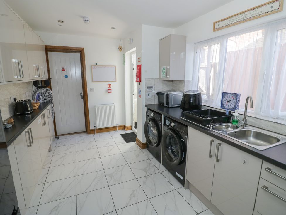 A kitchen with washing machine and microwave at JMG House in West Bromwich