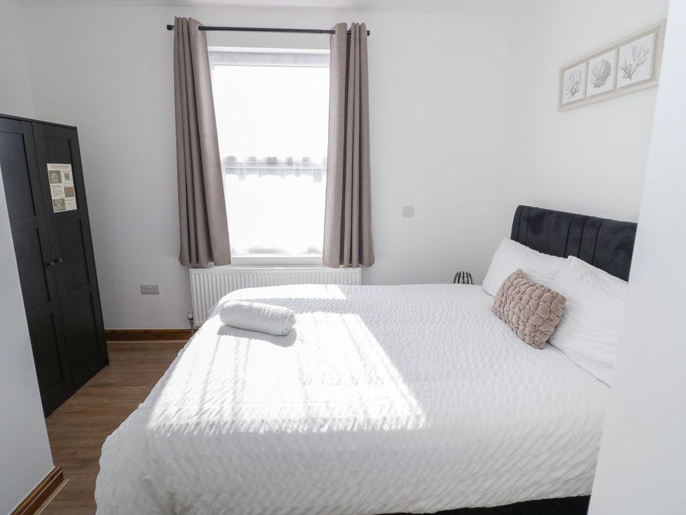 A bedroom with a bed and curtains at JMG House in West Bromwich