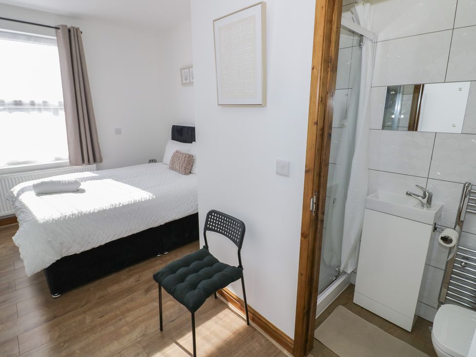 A bedroom with a bed and an ensuite bathroom at JMG House in West Bromwich