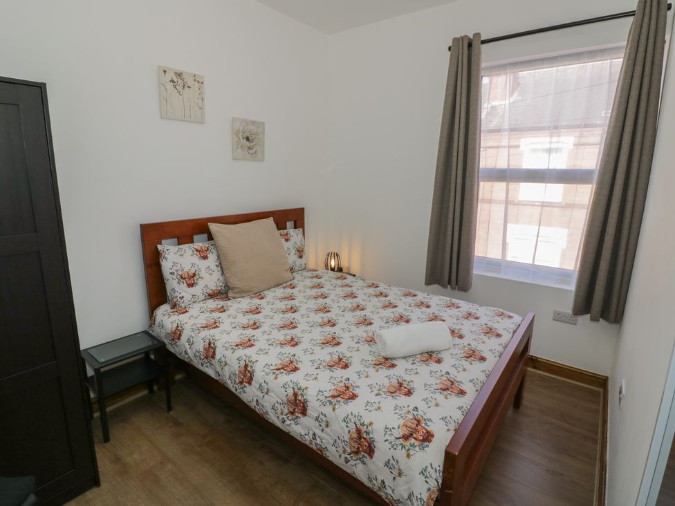 A bedroom with a bed and side table at JMG House West Bromwich