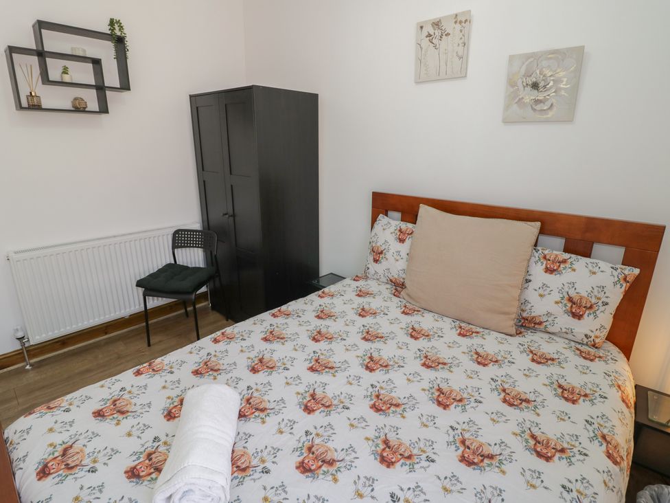 A bedroom with a bed and wardrobe at JMG House in West Bromwich