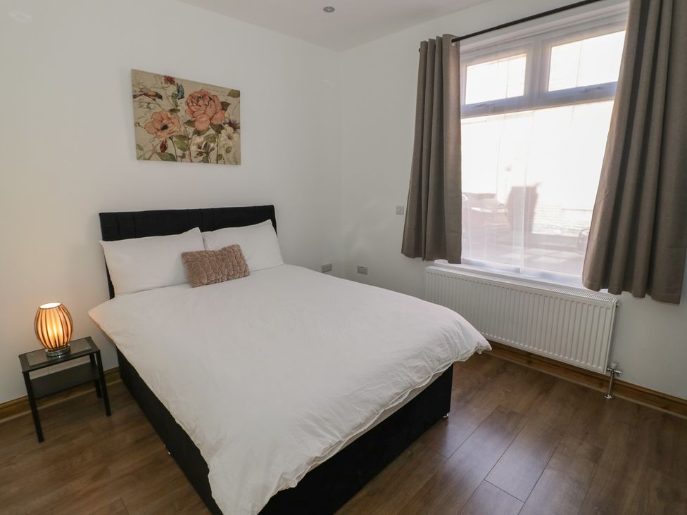 A bedroom with a double bed and side table at JMG House West Bromwich