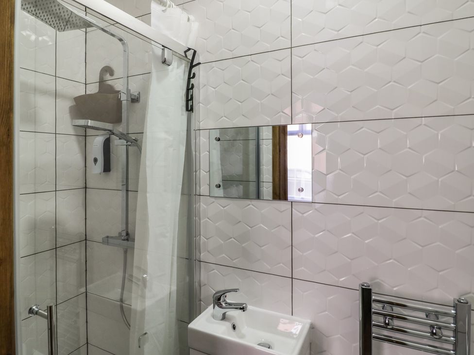 A bathroom with shower, sink, and mirror at JMG House in West Bromwich