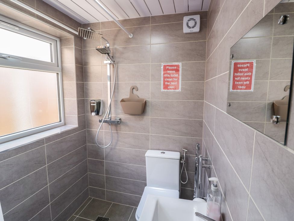 A bathroom with a shower, toilet, and sink at JMG House in West Bromwich