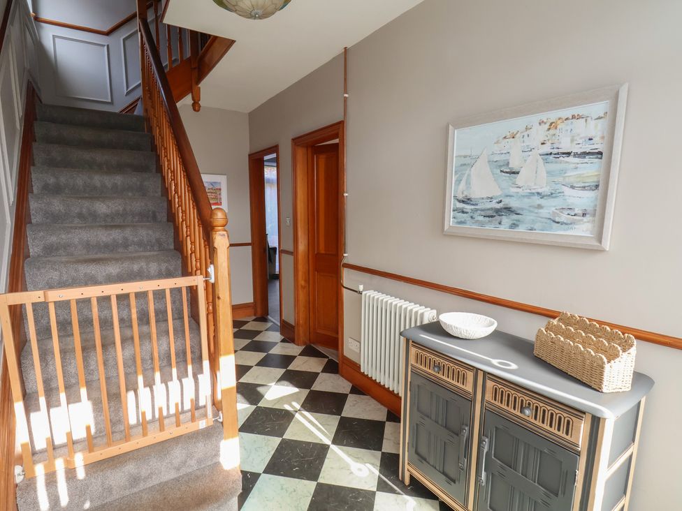 A hallway with staircase and console table at 44 Love Lane in Whitby