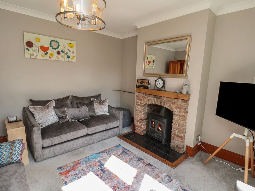 A living room with a fireplace and sofa at 44 Love Lane, Whitby