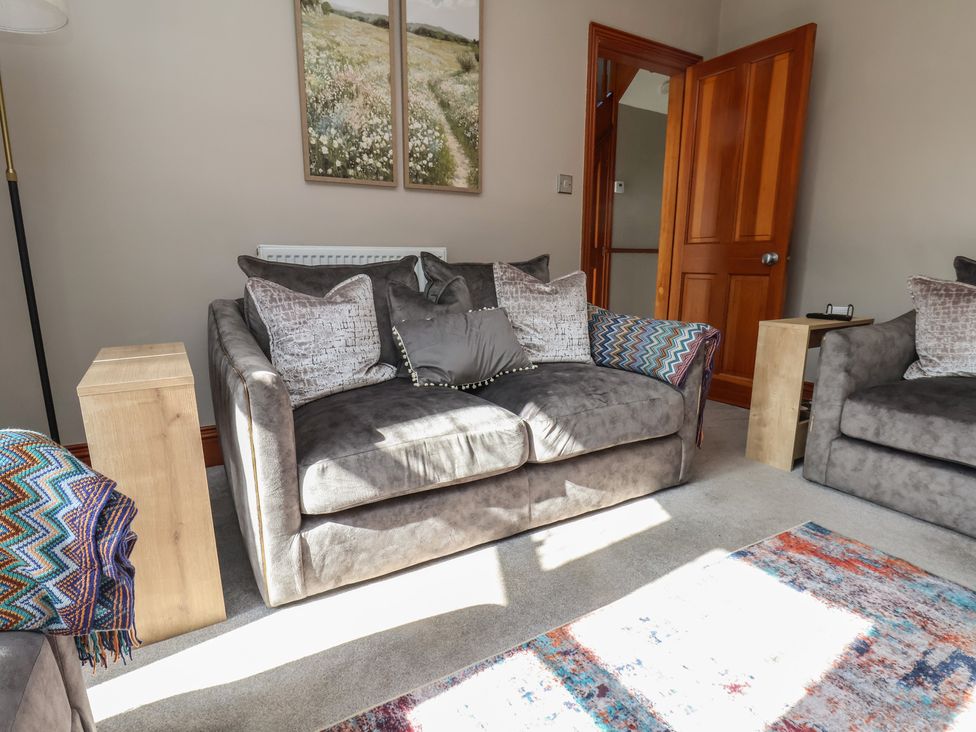 A living room with a sofa and side table at 44 Love Lane in Whitby