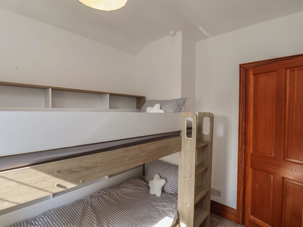 A bedroom with a bunk bed and wooden door at 44 Love Lane, Whitby