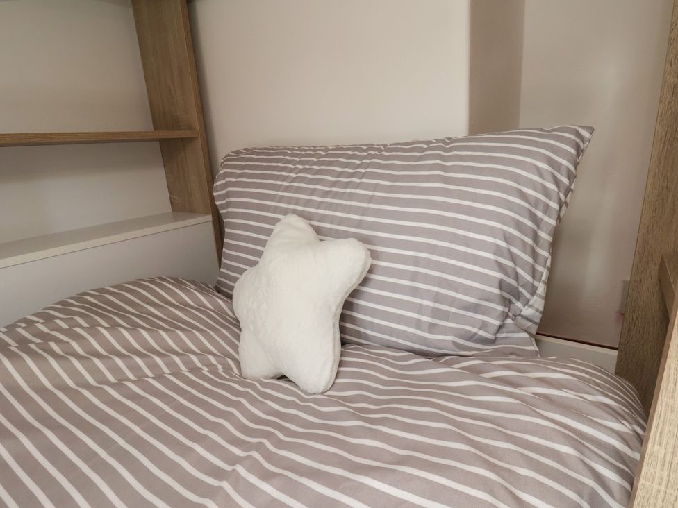 A bed with striped bedding and a decorative star pillow at 44 Love Lane in Whitby