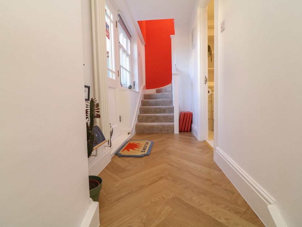 A hallway with a staircase and a welcome mat at Tower Cottage Nottingham