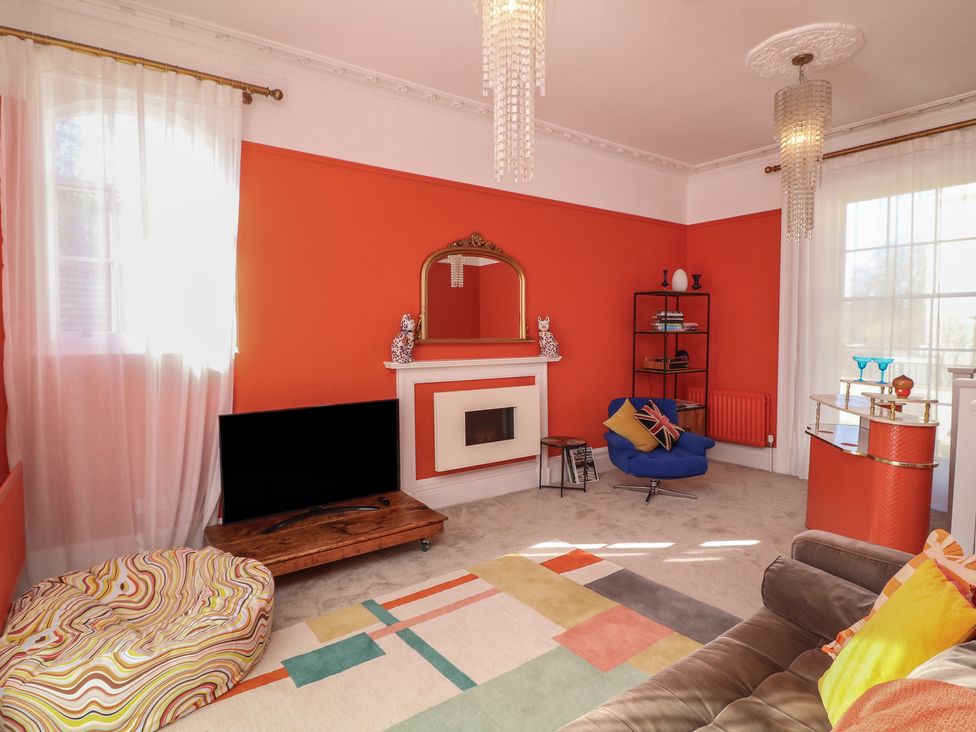 A living room with a television and a fireplace at Tower Cottage Nottingham