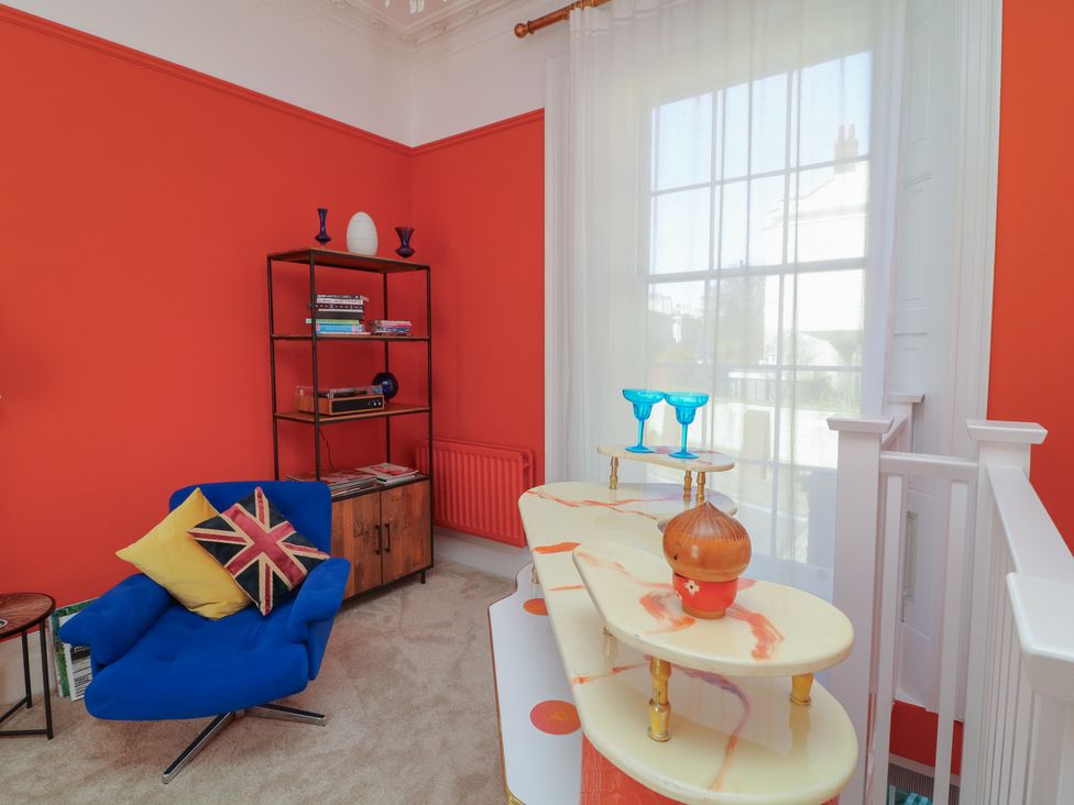 A living room with an armchair and decorative items at Tower Cottage in Nottingham