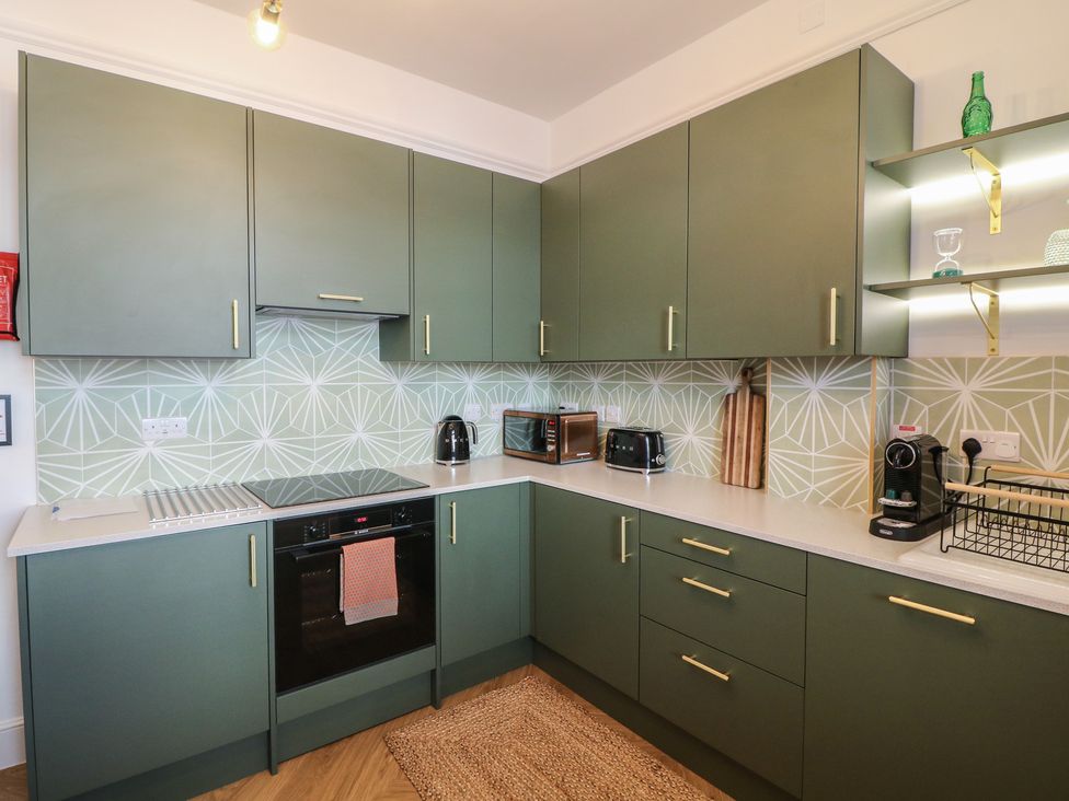 A kitchen with cabinets and appliances at Tower Cottage in Nottingham