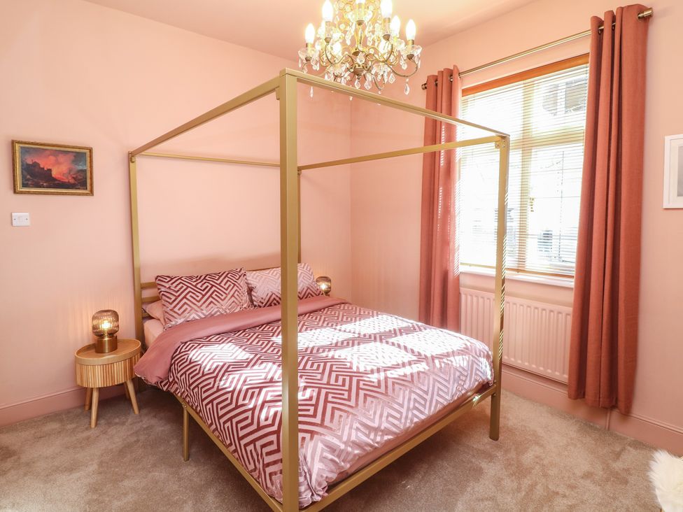 A bedroom with a canopy bed and nightstand at Tower Cottage in Nottingham