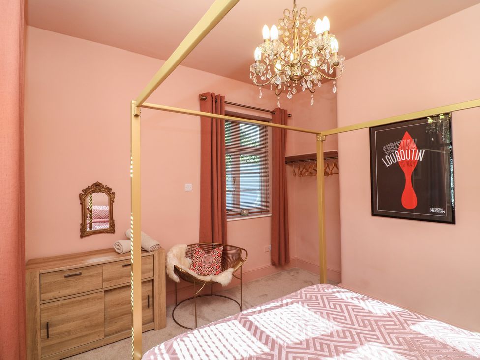 A bedroom with a bed and chandelier at Tower Cottage in Nottingham