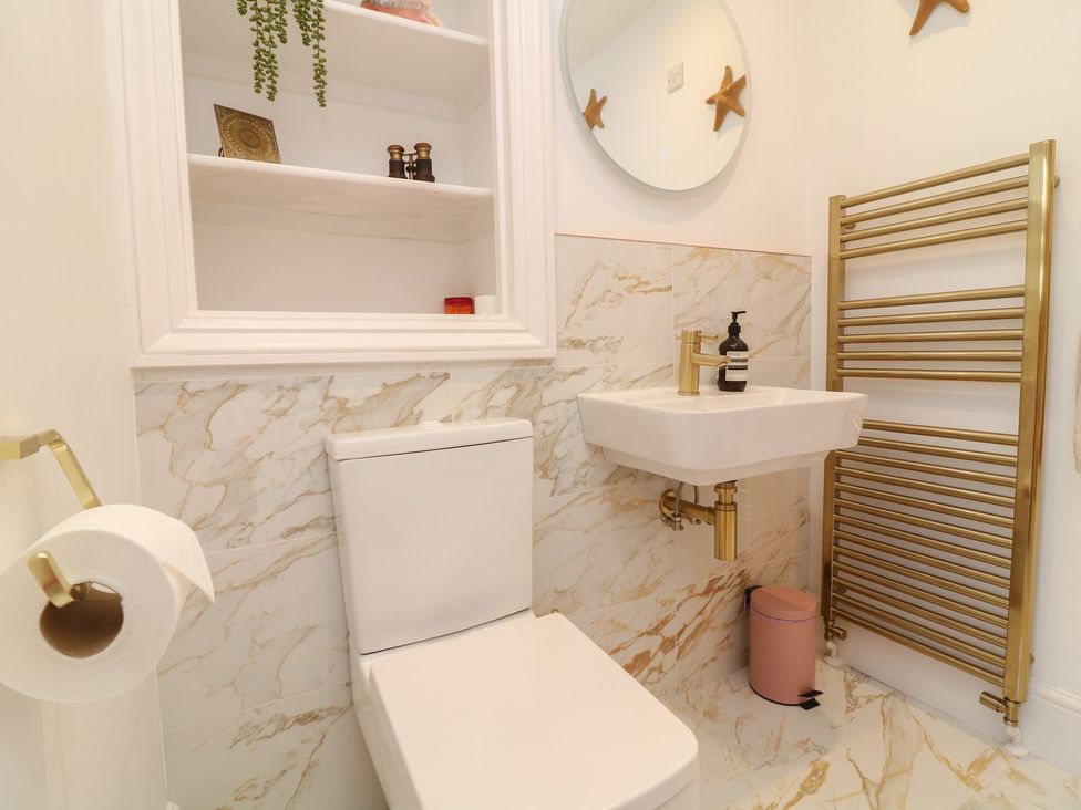 A bathroom with a toilet, sink, and towel rail at Tower Cottage in Nottingham