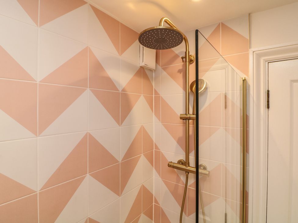 A shower with tiles and a glass door at Tower Cottage Nottingham