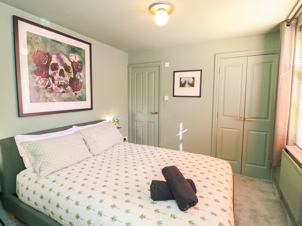 A bedroom with a bed and artwork at Tower Cottage Nottingham