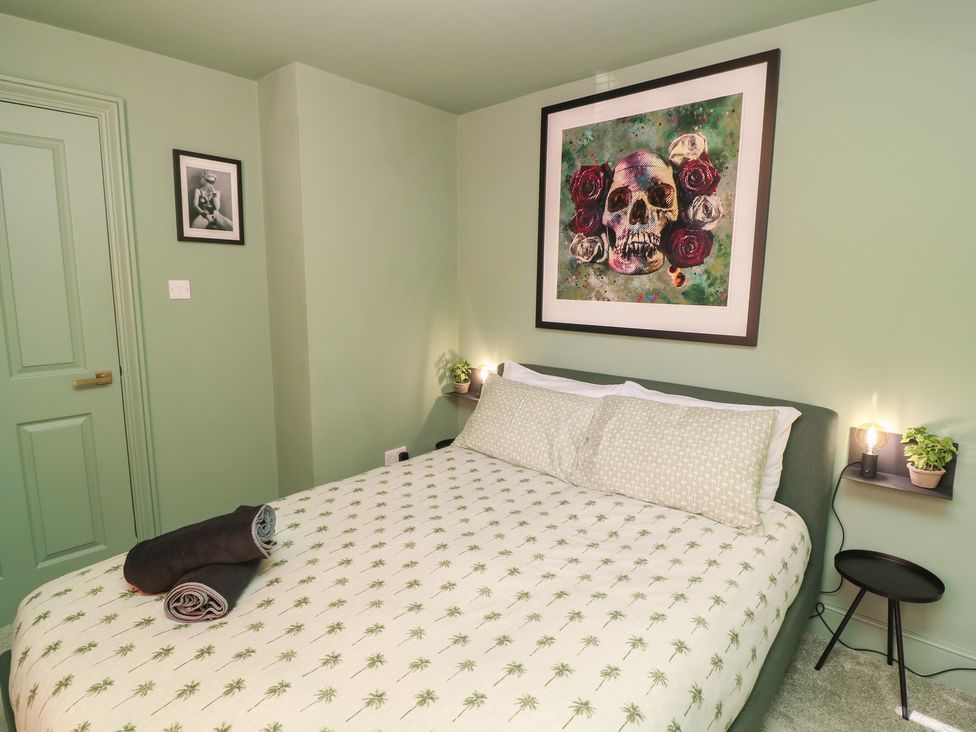 A bedroom with a bed and wall art at Tower Cottage Nottingham