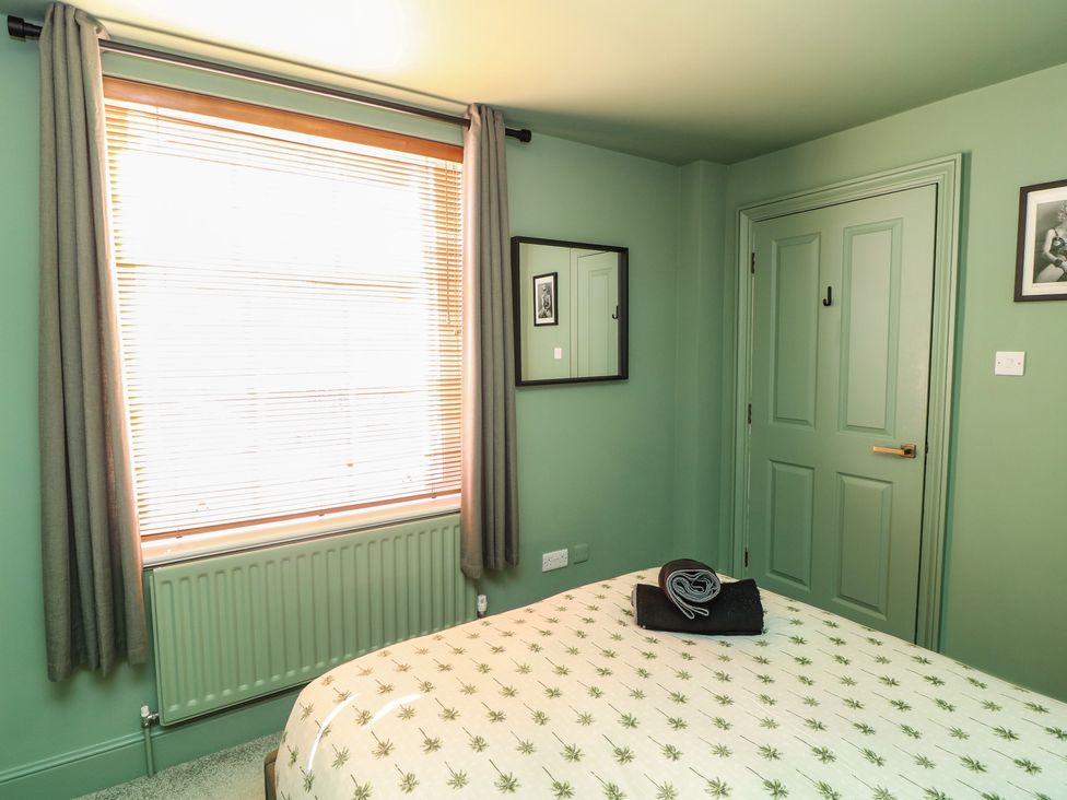 A bedroom with a bed and window at Tower Cottage in Nottingham
