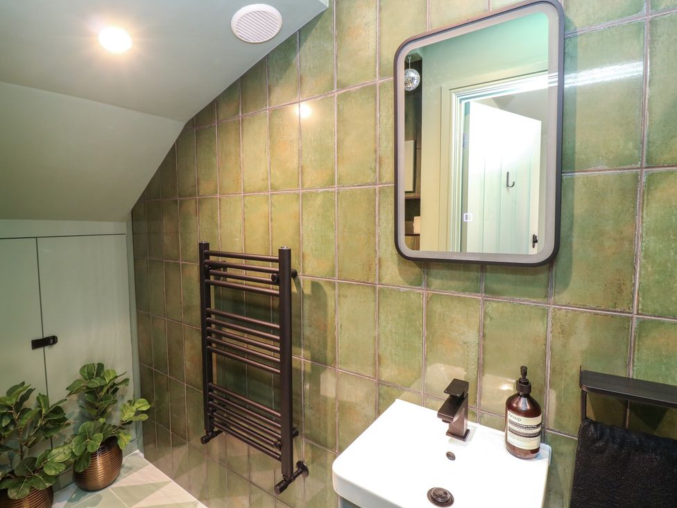 A bathroom with a sink and mirror at Tower Cottage Nottingham