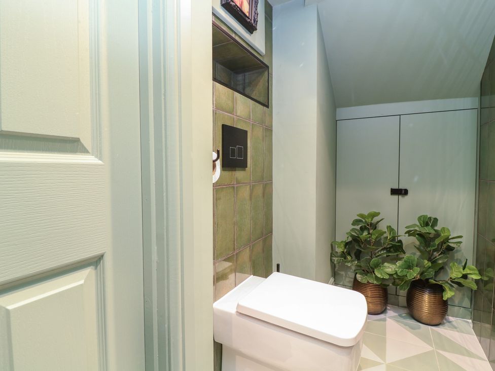 A bathroom with a toilet and storage cabinet at Tower Cottage Nottingham