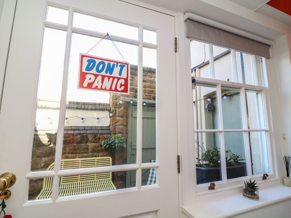 A window with a sign and a view of a courtyard at Tower Cottage Nottingham