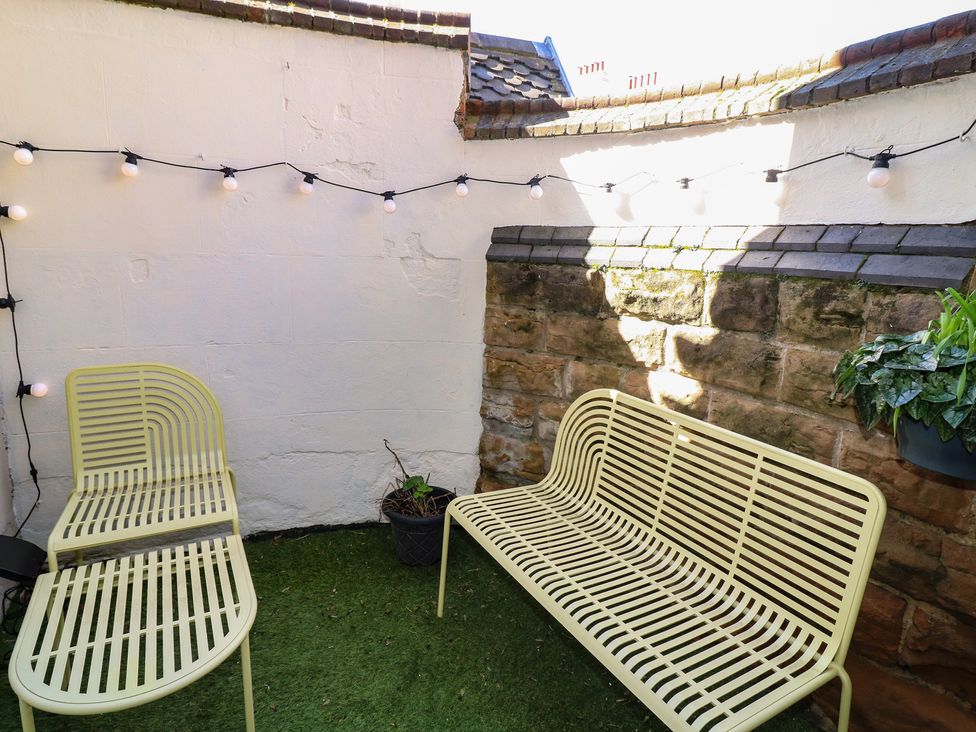 An outdoor area with seating and string lights at Tower Cottage Nottingham