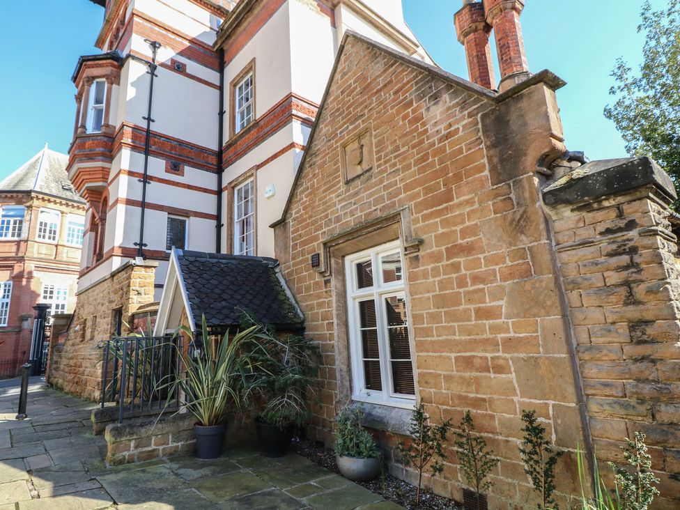 A building exterior with a stone wall and plants at Tower Cottage Nottingham