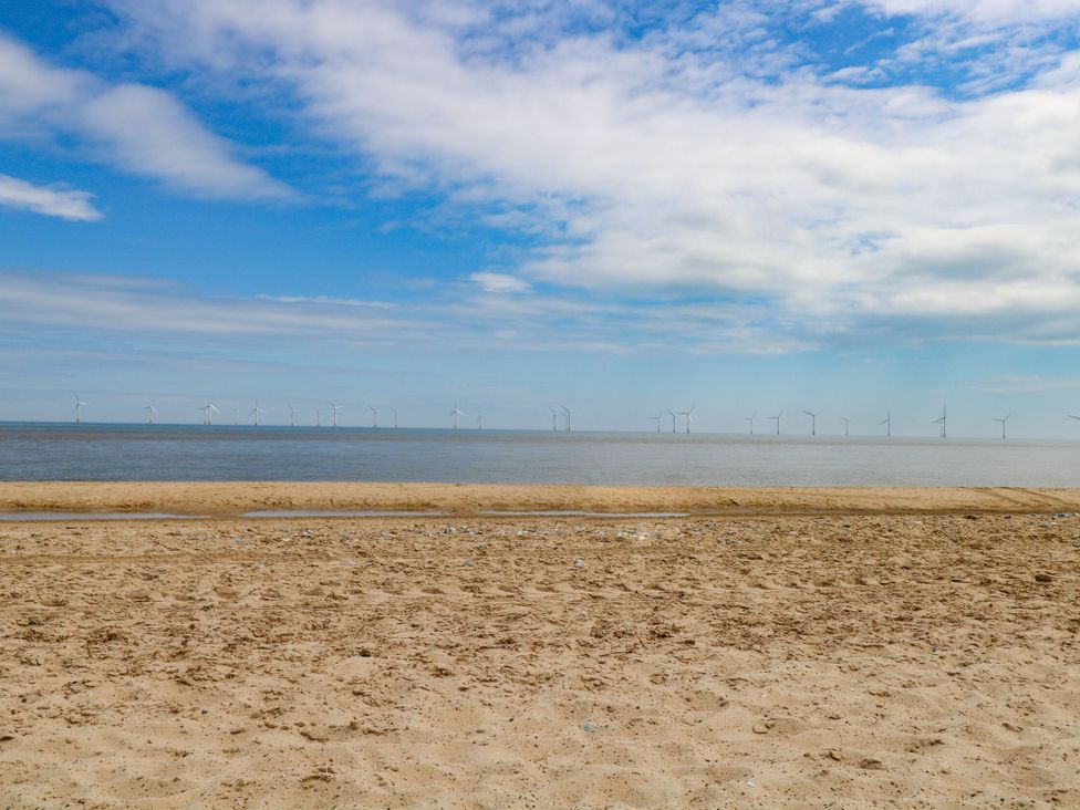 A beach view with wind turbines in the distance at Mabby in Great Yarmouth