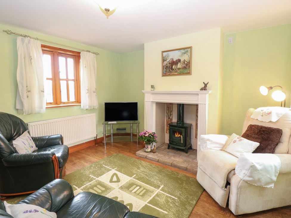 A living room with a fireplace and couch at Mabby in Caister-On-Sea