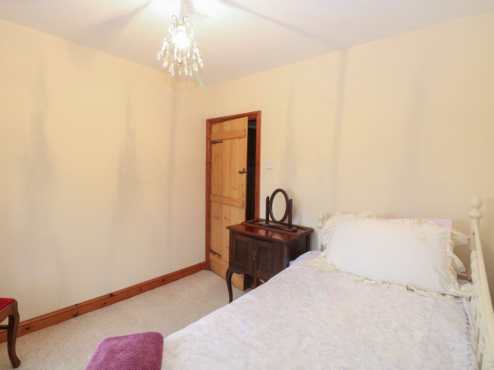 A bedroom with a bed and a wooden table at Mabby in Caister-On-Sea