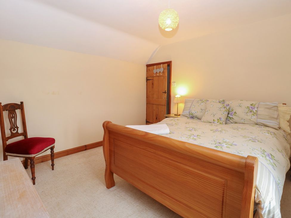 A bedroom with a bed and chair at Mabby in Caister-On-Sea
