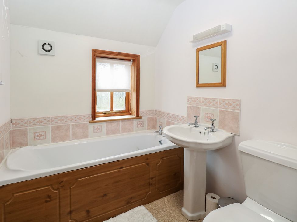 A bathroom with a bath tub, sink, and toilet at Mabby in Caister-On-Sea