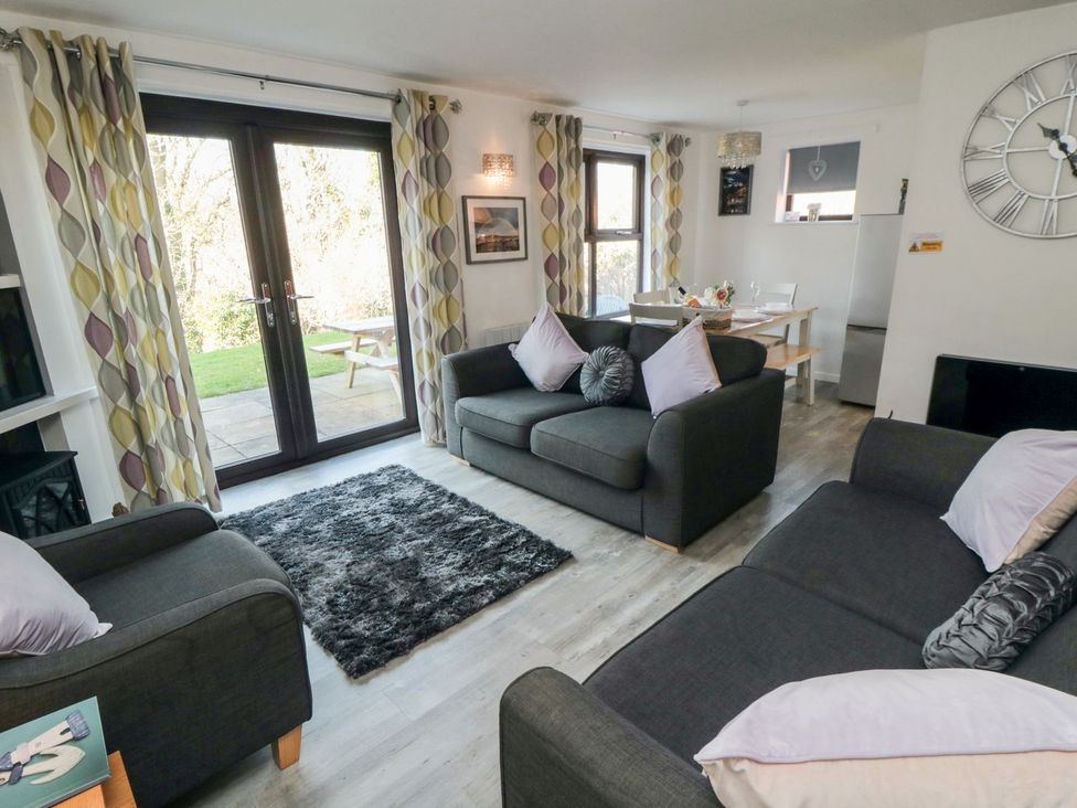 A living room with sofas and a table at Cha Cha's Cottage in Whitby