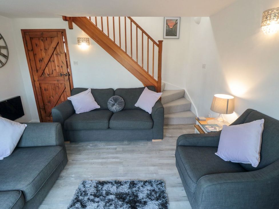 A living room with a sofa and table at Cha Cha's Cottage in Whitby